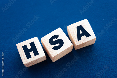 HSA abbreviation is written on wooden cubes on blue background. Concept. Health Savings Account. photo