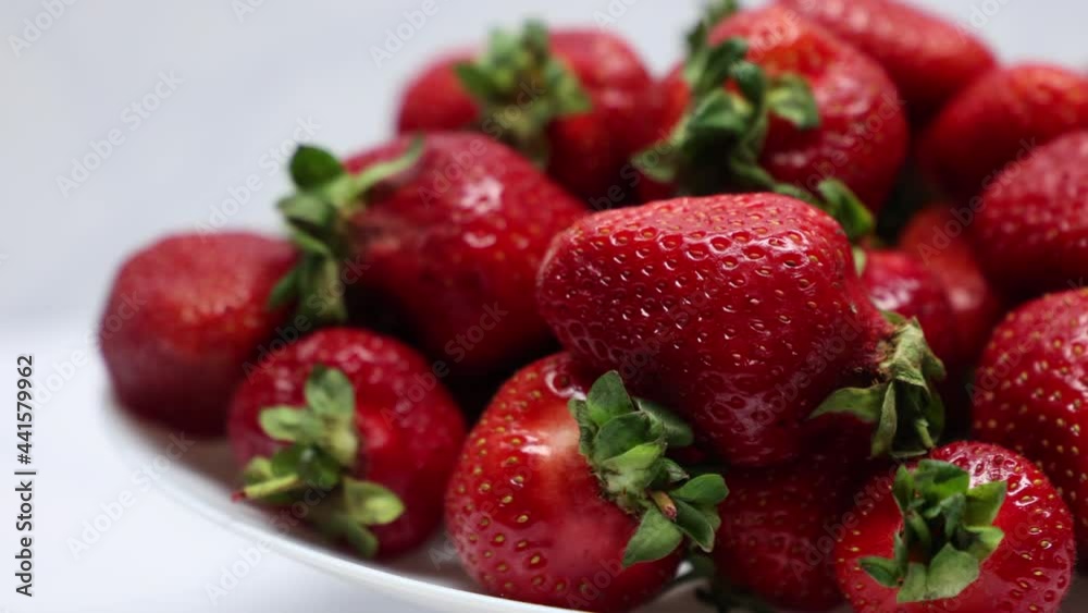 Rotate Fresh Delicious Ripe Red Strawberries On A White Plate Background. Close Up. Rotate Fresh Delicious Ripe Red Strawberries On A White Plate Background. Close Up.