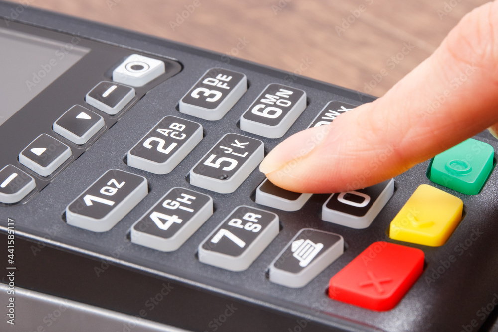 Hand of woman using credit card reader to enter PIN code. Cashless paying. Finance and banking Hand of woman using credit card reader to enter PIN code. Cashless paying. Finance and banking