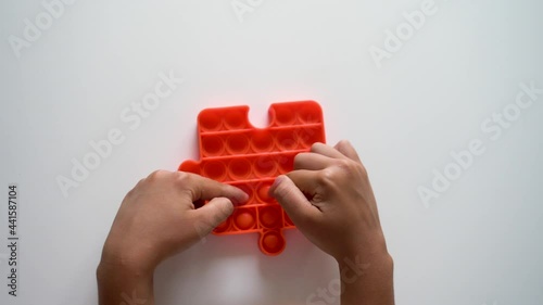 the hands of a child playing pop it
