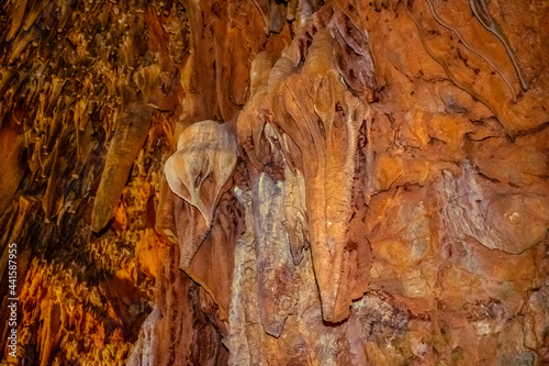 Brown stone mineral formations on the wall in Damlatas cave in Alanya (Turkey), close-up. Natural abstract brown-orange background of stalactites and stalagmites