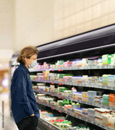 Supermarket shopping, face mask ,Young man shopping in supermarket, reading product information.
