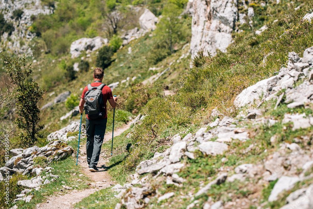 Traveler with backpack trekking on cliff