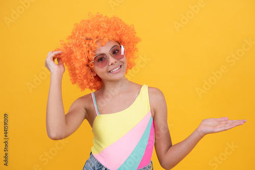 april fools day. happy childhood. birthday party. funny kid in curly clown wig. having fun.