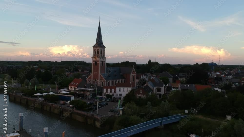 Beautiful church tower and old town by river in aerial drone view Beautiful church tower and old town by river in aerial drone view