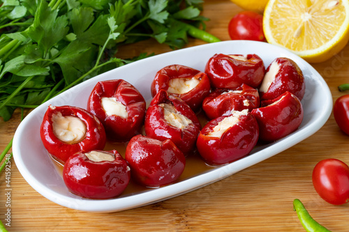 Cheese filled cherry peppers on wooden background. Local name peynir dolgulu kiraz biberi photo