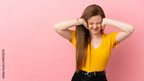 Teenager girl over isolated pink background frustrated and covering ears