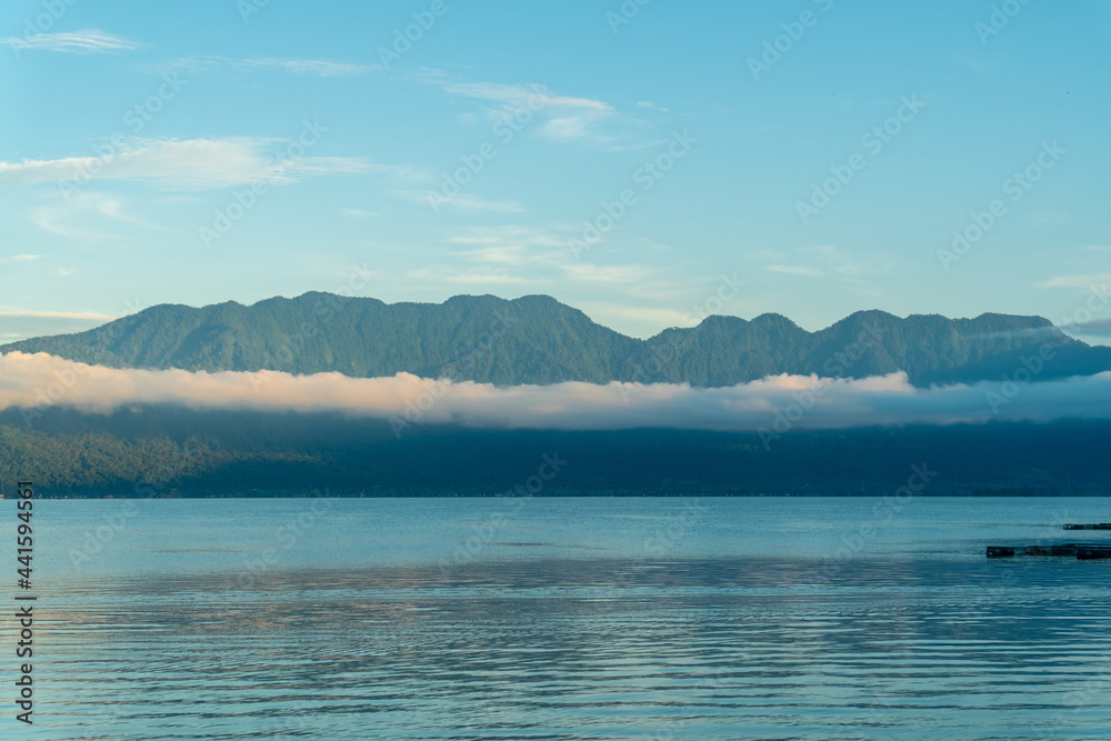 Landscape of Maninjau Lake in West Sumatra, Indonesia in the Morning with few clouds in the mountains. beautiful landscape of Indonesia's nature.