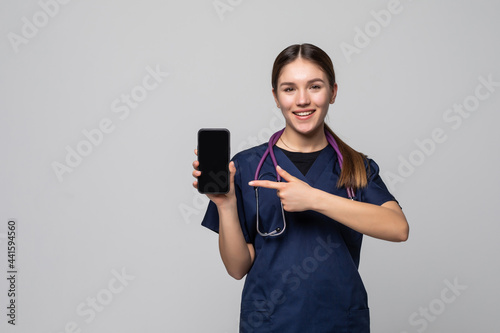 Beautiful female doctor showing a smart phone screen on a white background