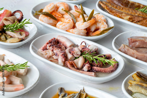 Set of Seafood Dishes. Seafood on a plate. On a white wooden background. Selective focus octopus salad. Lakerda, octopus salad, shrimp, fish salad
