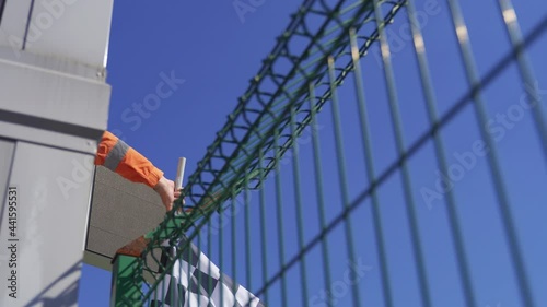 Man holding and waving Checkered race flag at finish line on a raceway. 
