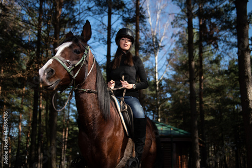 Beautiful Woman Rides a Horse Wearing a Helmet
