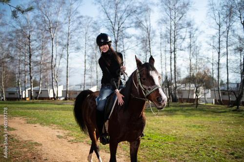 Young Woman Wearing Helmet and Riding Horse