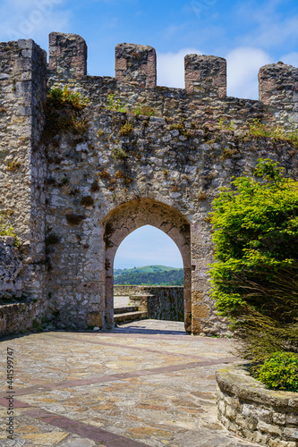 Medieval castle with stone wall and arched entrance gate in sunny day. Suances Santander. photo