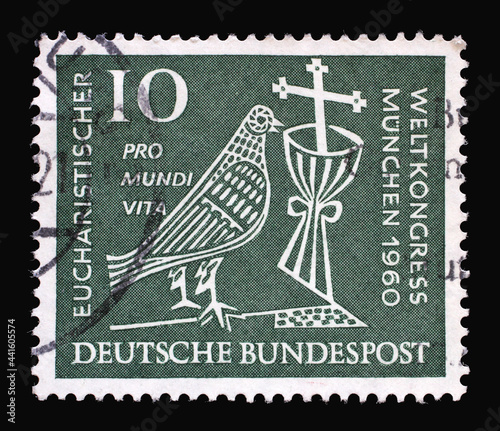 Stamp printed in Germany showing a stylized dove, cross and chalice. 37th Eucharistic World Congress in Munich, circa 1960 photo