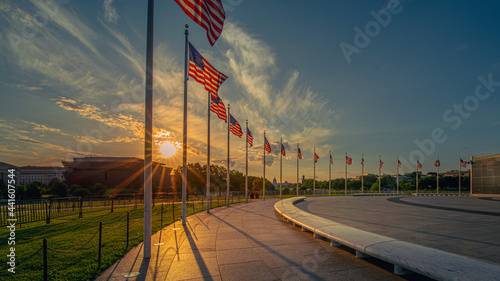 Sunrise over ring of American Flags around the Washington Monument in United States capitol with national mall and Smithsonian Museums in background.