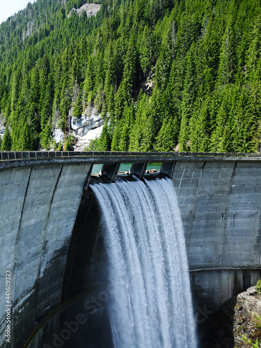 Galbenu dam during springtime. The water is overflowing the dam, forming a beautiful waterfall when spilling over it. Carpathia, Romania. photo