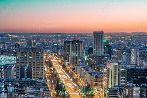 Vistas de la Castellana y sus edificios en Madrid durante la puesta de sol en un día despejado y sin nubes.