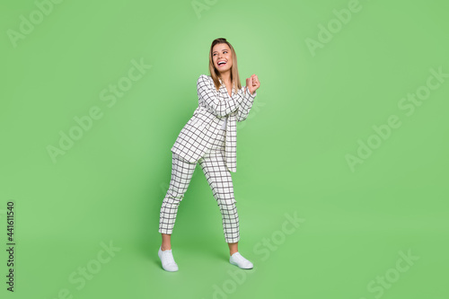 Full length body size view of attractive cheerful elegant chic lady dancing wearing formal suit having fun isolated over green color background