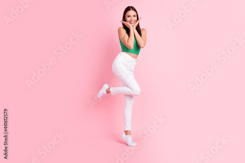 Full length body size photo smiling touching face woman in casual clothes isolated pastel pink color background
