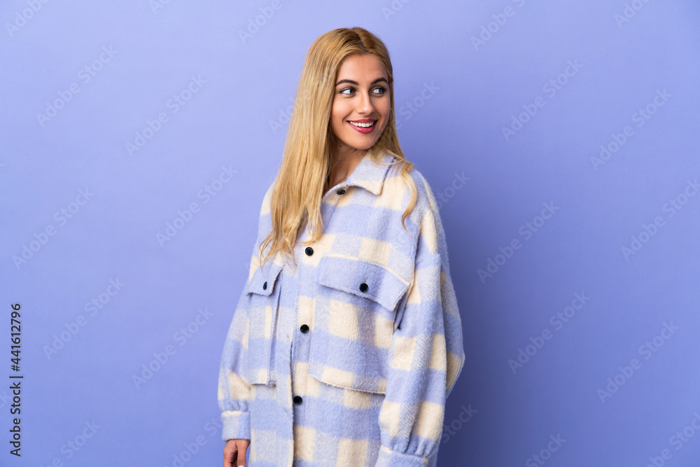 Young Uruguayan blonde woman over isolated background looking to the side and smiling Young Uruguayan blonde woman over isolated background looking to the side and smiling