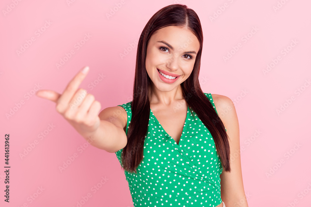Photo portrait woman showing come on gesture with finger isolated pastel pink color background Photo portrait woman showing come on gesture with finger isolated pastel pink color background