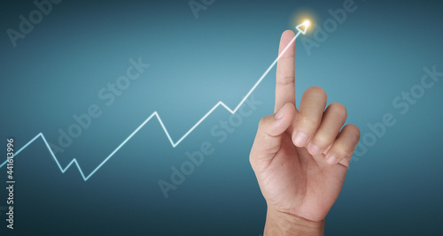 Hand touching graphs of financial indicator and accounting market chart
