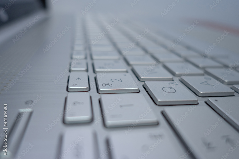 Close-up of a aluminum keyboard from a laptop. Side view.