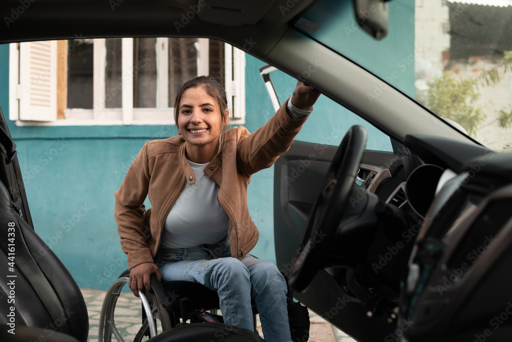 wheelchair woman in front of car and looking at camera. wheelchair woman in front of car and looking at camera.