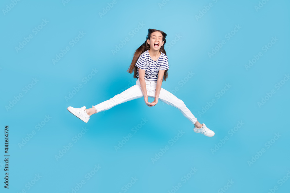 Full body photo of young excited girl happy positive smile jump up isolated over blue color background