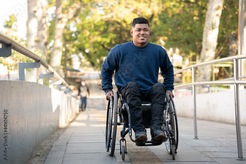 Fotografia person in wheelchair finishing to climb access ramp.