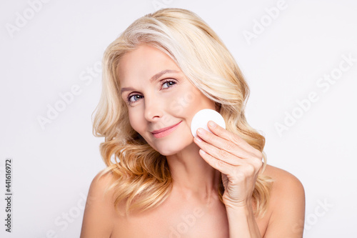 Photo of attractive aged woman happy positive smile remove makeup cotton pads toner isolated over grey color background