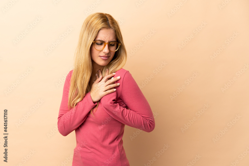 Young Uruguayan blonde woman over isolated background having a pain in the heart Young Uruguayan blonde woman over isolated background having a pain in the heart