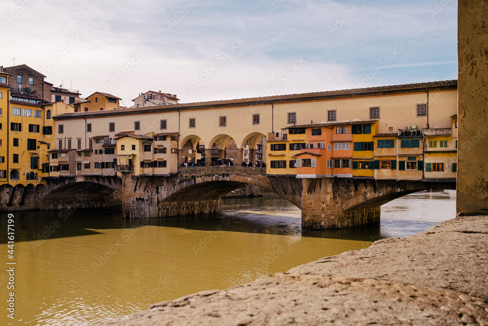 River Arno and famous bridge Ponte Vecchio in the sunny afternoon in Florence, Tuscany, Italy