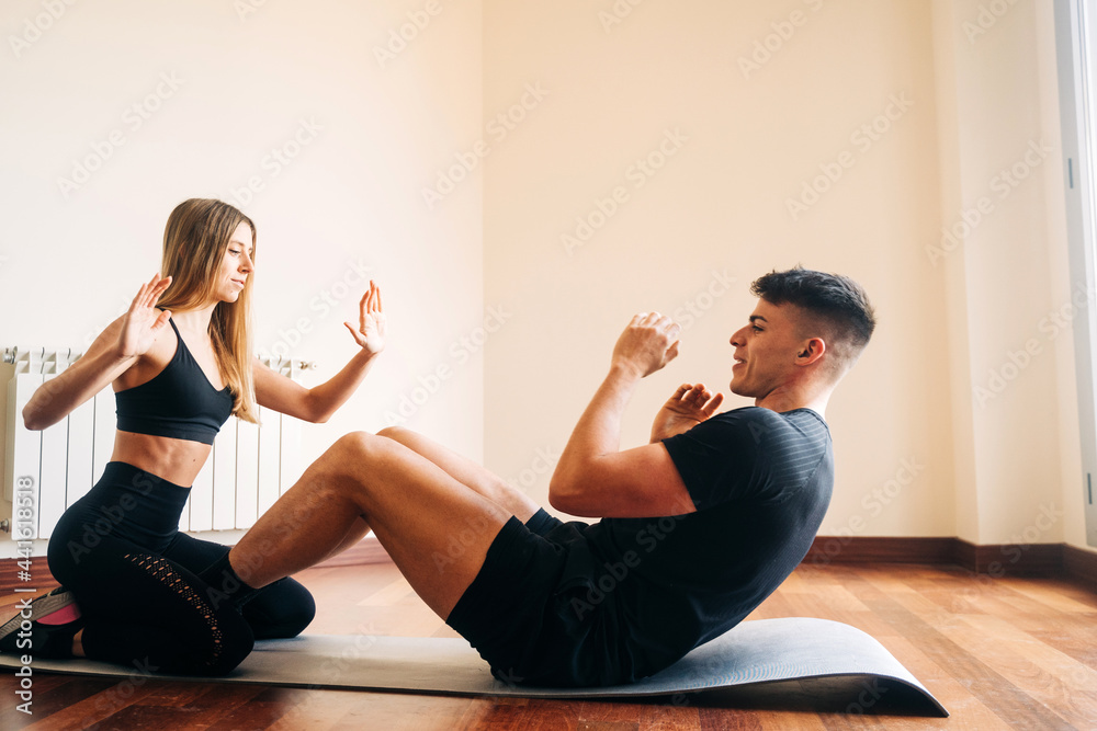 Fit man doing crunches with woman Fit man doing crunches with woman