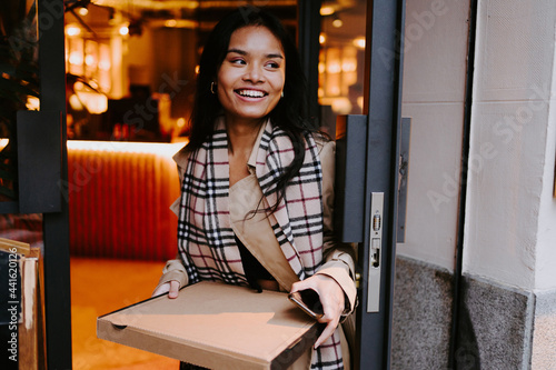 Asian woman picking up take out food in a restaurant