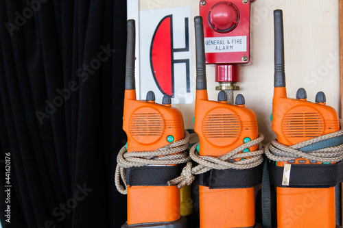 Three orange emergency radios on a ship near an alarm. Apply in case of general or fire alarm. photo