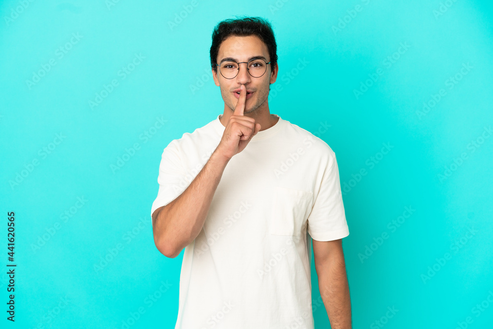 Caucasian handsome man over isolated blue background showing a sign of silence gesture putting finger in mouth Caucasian handsome man over isolated blue background showing a sign of silence gesture putting finger in mouth