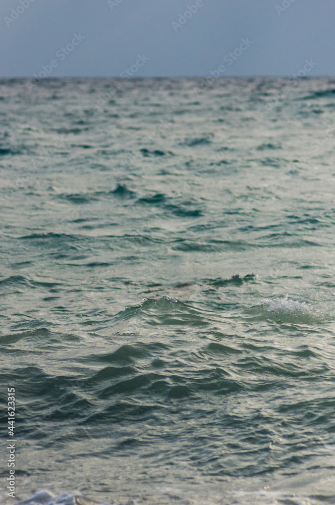sea landscape is a pebbly beach with waves in white foam