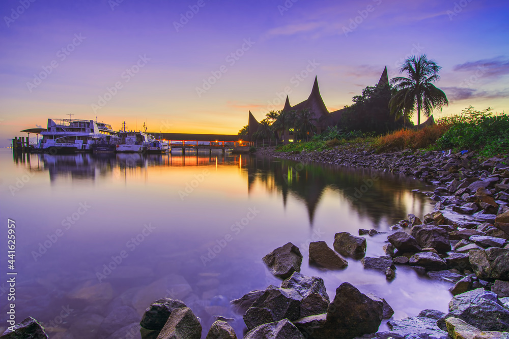 Enjoy the sunrise at the marina port with traditional houses and rocks as the background
