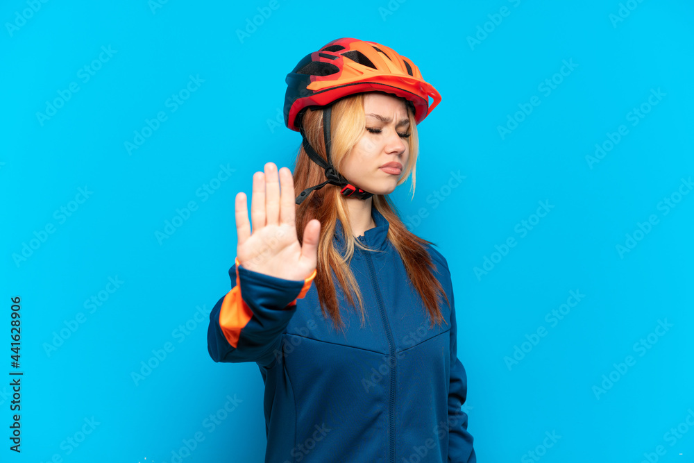 Young cyclist girl isolated on blue background making stop gesture and disappointed Young cyclist girl isolated on blue background making stop gesture and disappointed