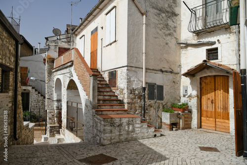 Fototapeta Naklejka Na Ścianę i Meble -  Candela, Italy, 06/21/2021. A small street between the old houses of a mediterranean village of Puglia region.