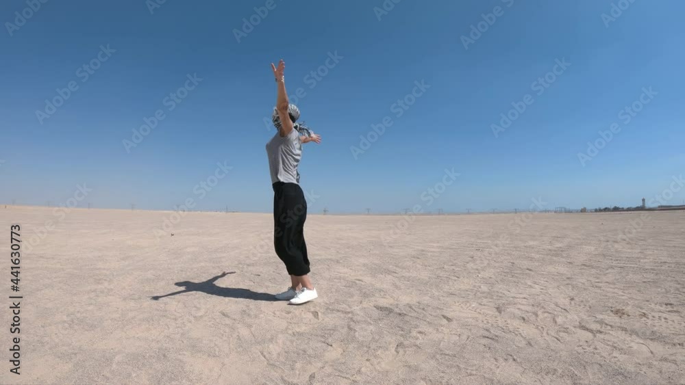 Young happy woman with open arms standing in the middle of the desert. Traveling, vacation concept. Young happy woman with open arms standing in the middle of the desert. Traveling, vacation concept.
