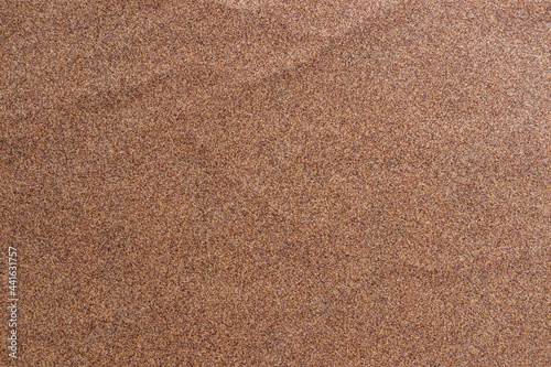Sandpaper texture background where you can see the red-brown sand grain pattern on the sandpaper, suitable as a background for inserting text. Copy Space for designers to use on sandpaper.