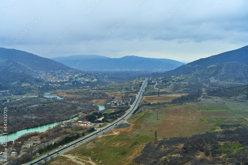 Natural landscape. View from a height on the track next to the river in the mountains Natural landscape. View from a height on the track next to the river in the mountains