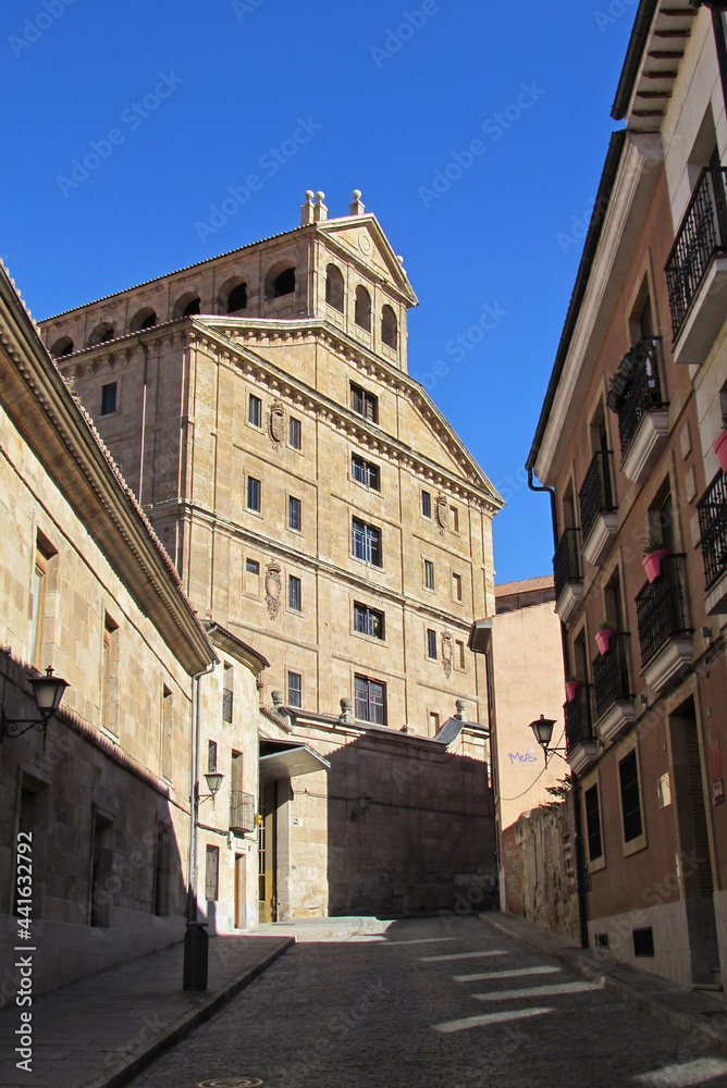 Walking by the street towards the facade of the Pontifical University of Salamanca.