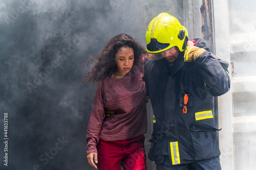 Obraz na płótnie Firefighter emergency rescue help young woman from dangerous smoke and burning building accident. - Safety and rescue operation comcept w salonie