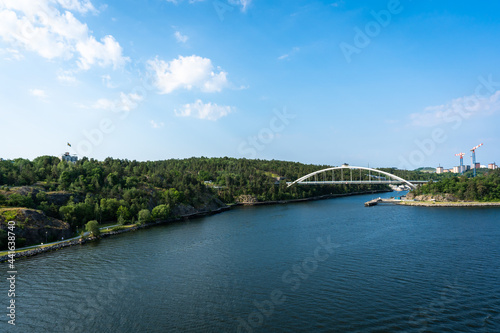 Beautiful panoramic view of Stockholm, Capital of Sweden. New bridge at Nacka district on sunny summer day. Green shores of the embankment of Lake Malaren. Blue sky white clouds.