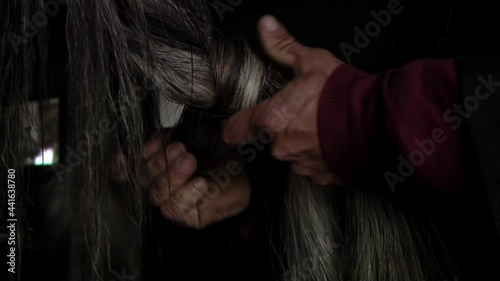 Farmer Hands making Braids of Horse Hair at Stable. Close Up.  photo