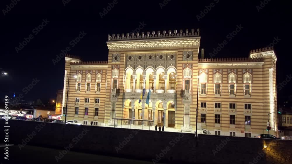 Sarajevo City Hall building, known as Vijecnica at night with city traffic an people. Timelapse Sarajevo City Hall building, known as Vijecnica at night with city traffic an people. Timelapse